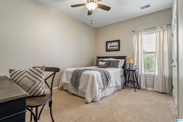 bedroom featuring light colored carpet, baseboards, visible vents, and a ceiling fan