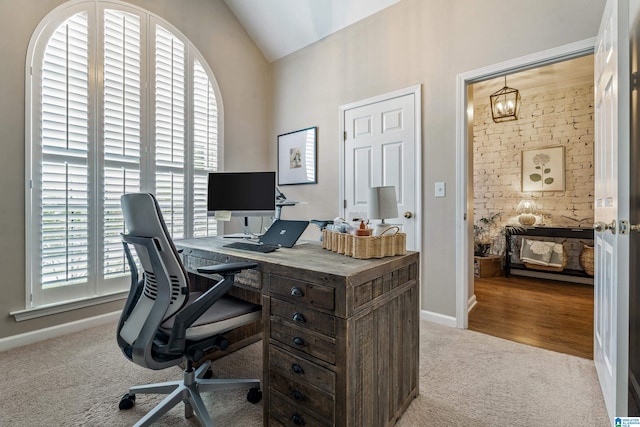carpeted office space featuring baseboards, lofted ceiling, and a notable chandelier