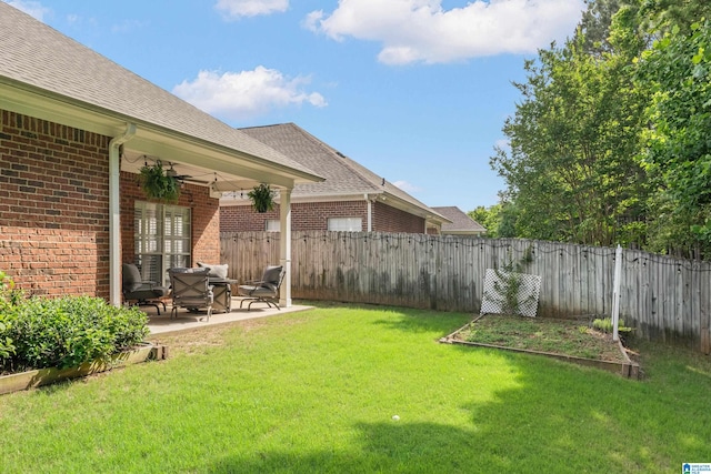 view of yard featuring a patio, a fenced backyard, and a vegetable garden