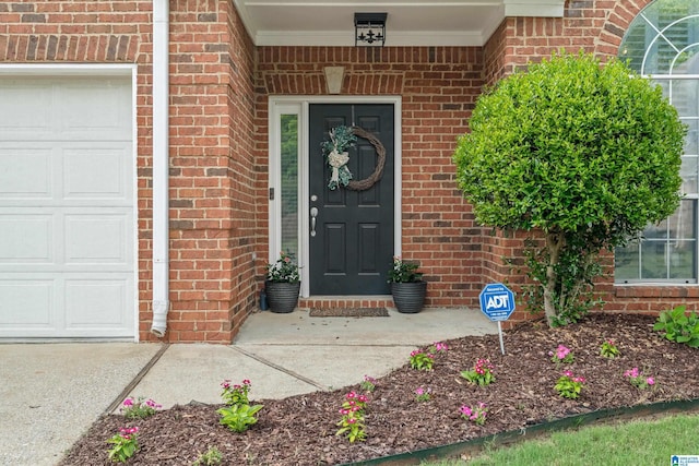 property entrance with brick siding and an attached garage