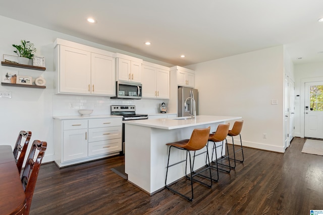530 10th Ave S, Birmingham, AL 35205 - kitchen with a kitchen breakfast bar, a center island with sink, light countertops, dark wood finished floors, and appliances with stainless steel finishes