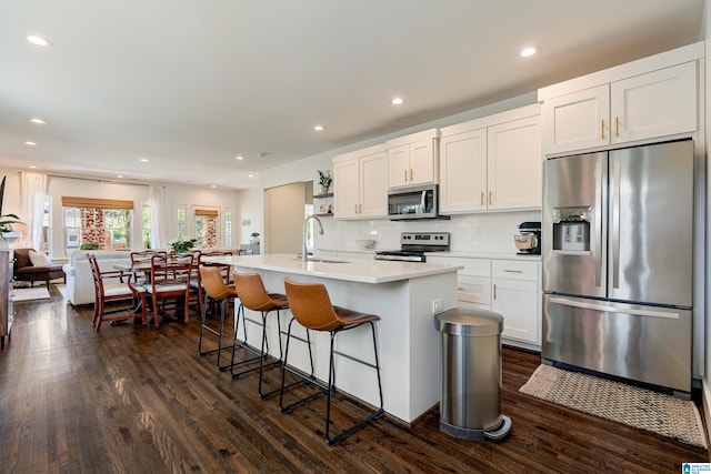 530 10th Ave S, Birmingham, AL 35205 - kitchen featuring a sink, light countertops, dark wood finished floors, stainless steel appliances, and a kitchen bar