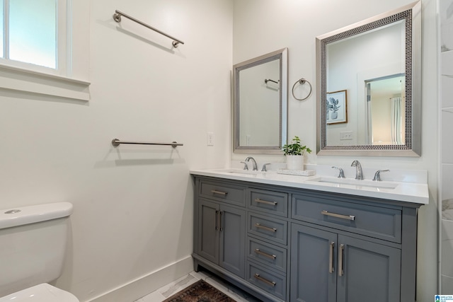 530 10th Ave S, Birmingham, AL 35205 - bathroom featuring baseboards, a sink, double vanity, and toilet