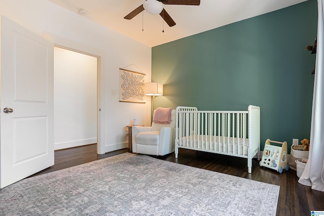 530 10th Ave S, Birmingham, AL 35205 - bedroom with baseboards, a ceiling fan, a crib, and wood finished floors