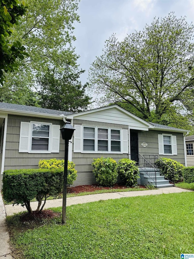 single story home featuring a front lawn