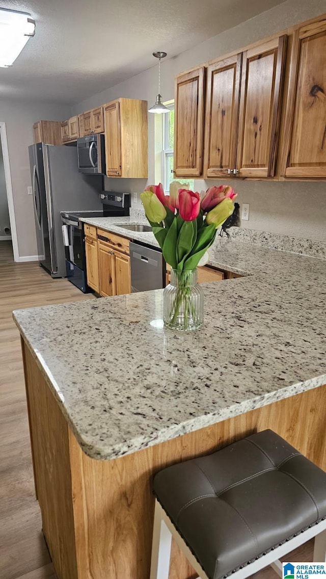 5482 Hackberry Ln N, Gadsden, AL 35903 - kitchen with a peninsula, appliances with stainless steel finishes, and light stone countertops