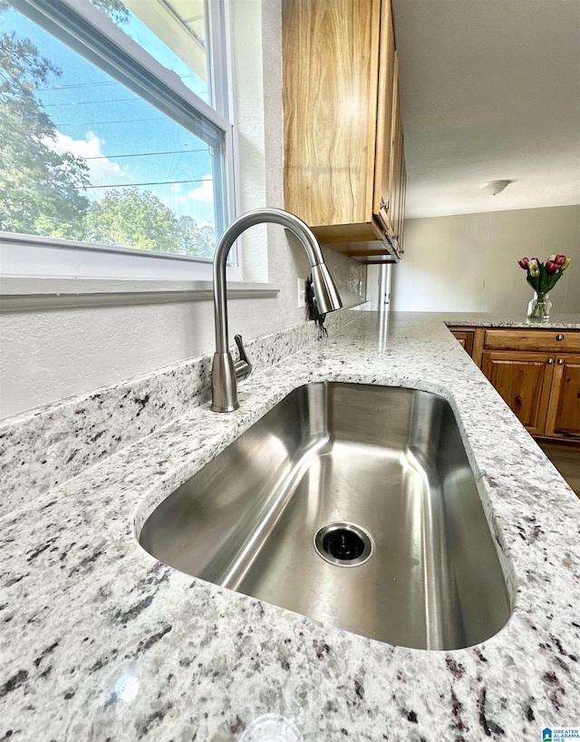 5482 Hackberry Ln N, Gadsden, AL 35903 - room details featuring light stone countertops, brown cabinetry, and a sink