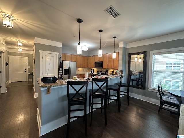 475 River Forest Ln Unit 1250, Talladega, AL 35160 - kitchen with brown cabinetry, a breakfast bar area, visible vents, appliances with stainless steel finishes, and dark wood-type flooring