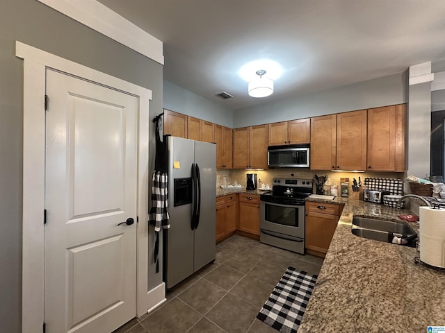 475 River Forest Ln Unit 1250, Talladega, AL 35160 - kitchen with brown cabinets, appliances with stainless steel finishes, a sink, dark tile patterned floors, and visible vents