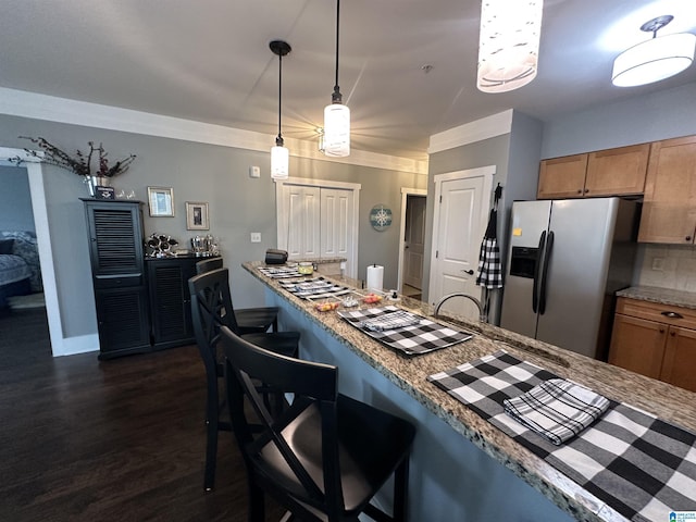 475 River Forest Ln Unit 1250, Talladega, AL 35160 - kitchen featuring pendant lighting, dark wood-style flooring, a kitchen bar, brown cabinets, and stainless steel fridge with ice dispenser