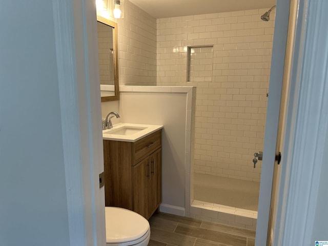 bathroom featuring vanity, wood tiled floor, toilet, and a shower stall