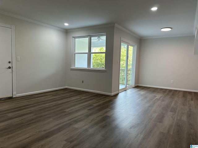 unfurnished room with crown molding, baseboards, and dark wood-style floors