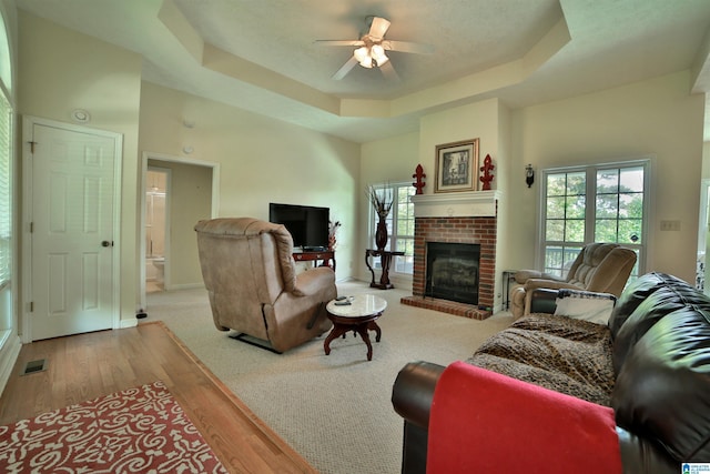 50 County Road 4311, Wedowee, AL 36278 - living room with a healthy amount of sunlight, a ceiling fan, visible vents, a brick fireplace, and a raised ceiling