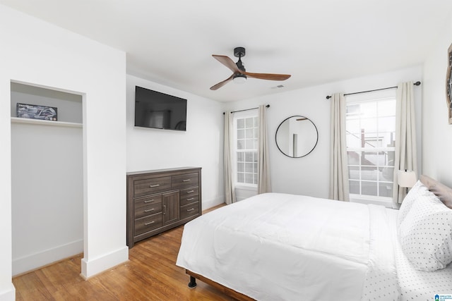 bedroom with baseboards, a ceiling fan, and wood finished floors