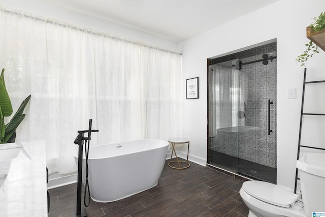 full bathroom with toilet, baseboards, wood tiled floor, a freestanding bath, and a shower stall