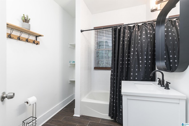 bathroom with baseboards, wood finish floors, shower / tub combo, and vanity