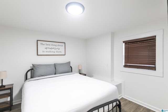 bedroom featuring baseboards and wood finished floors