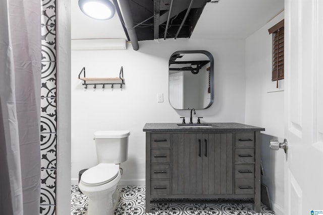 bathroom featuring toilet, baseboards, tile patterned floors, and vanity