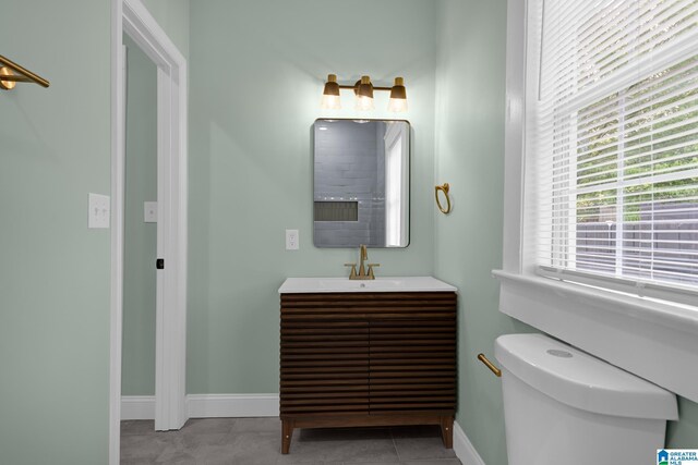 829 1st St SW, Birmingham, AL 35211 - bathroom with baseboards, vanity, toilet, and tile patterned flooring