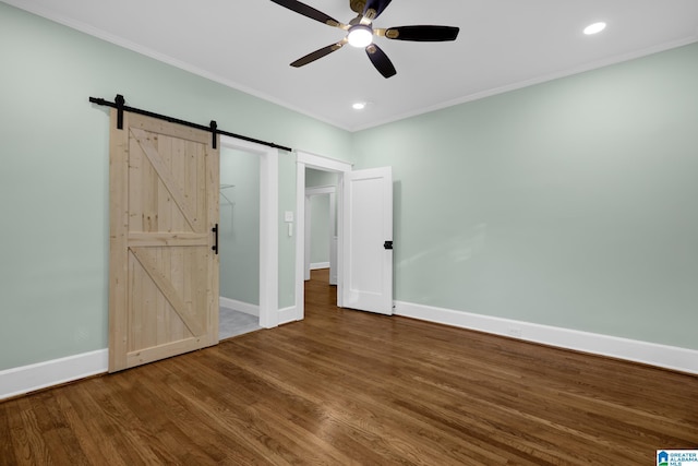 829 1st St SW, Birmingham, AL 35211 - unfurnished bedroom featuring crown molding, a barn door, wood finished floors, baseboards, and recessed lighting