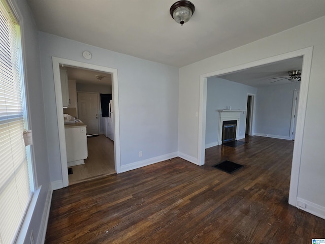 interior space with a healthy amount of sunlight, baseboards, visible vents, and dark wood-type flooring