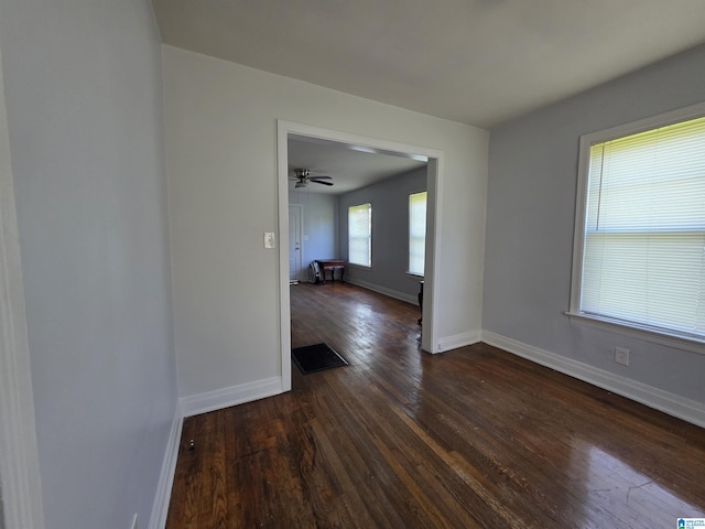 spare room with baseboards, dark wood-style floors, and visible vents