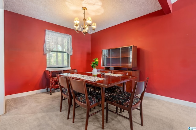 dining space featuring an inviting chandelier, baseboards, a textured ceiling, and light colored carpet