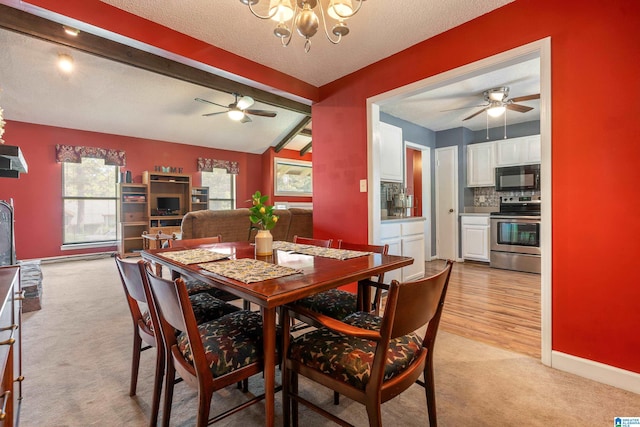 dining area with a textured ceiling, beamed ceiling, light colored carpet, and ceiling fan with notable chandelier