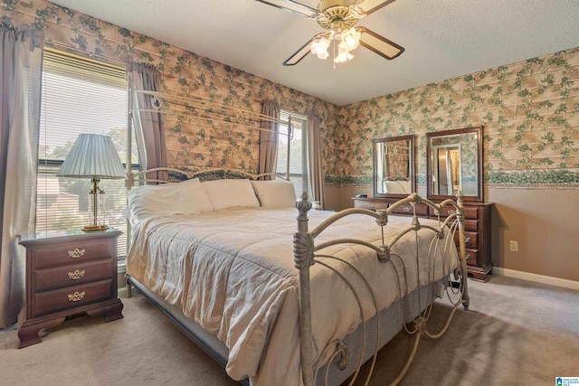 bedroom featuring carpet floors, a textured ceiling, a wainscoted wall, wallpapered walls, and baseboards