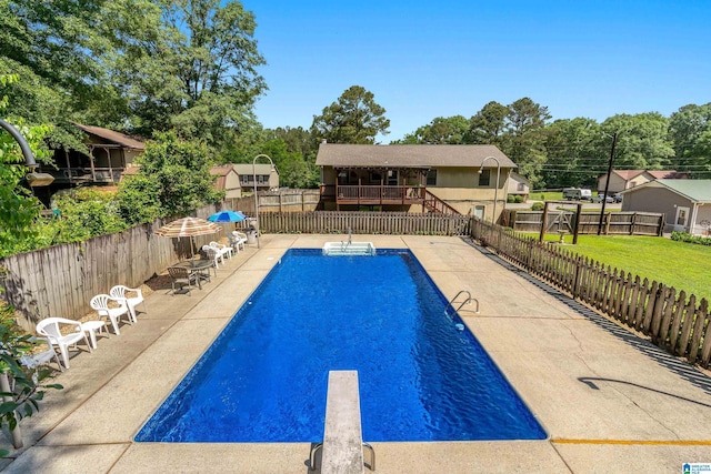 view of swimming pool featuring a fenced in pool, a diving board, a patio area, and fence