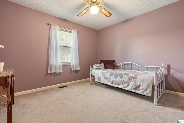 carpeted bedroom with baseboards, a textured ceiling, and visible vents