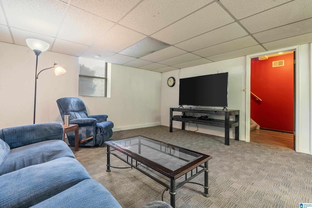 carpeted living area with baseboards, a drop ceiling, and visible vents