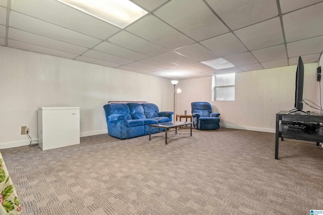 sitting room featuring baseboards, carpet flooring, and a drop ceiling