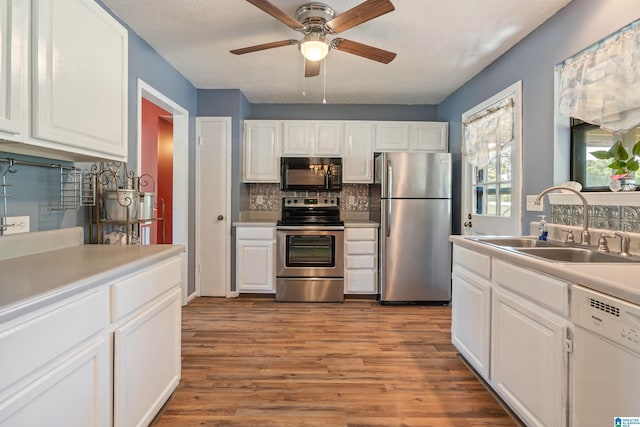 kitchen with backsplash, white cabinetry, appliances with stainless steel finishes, and a sink