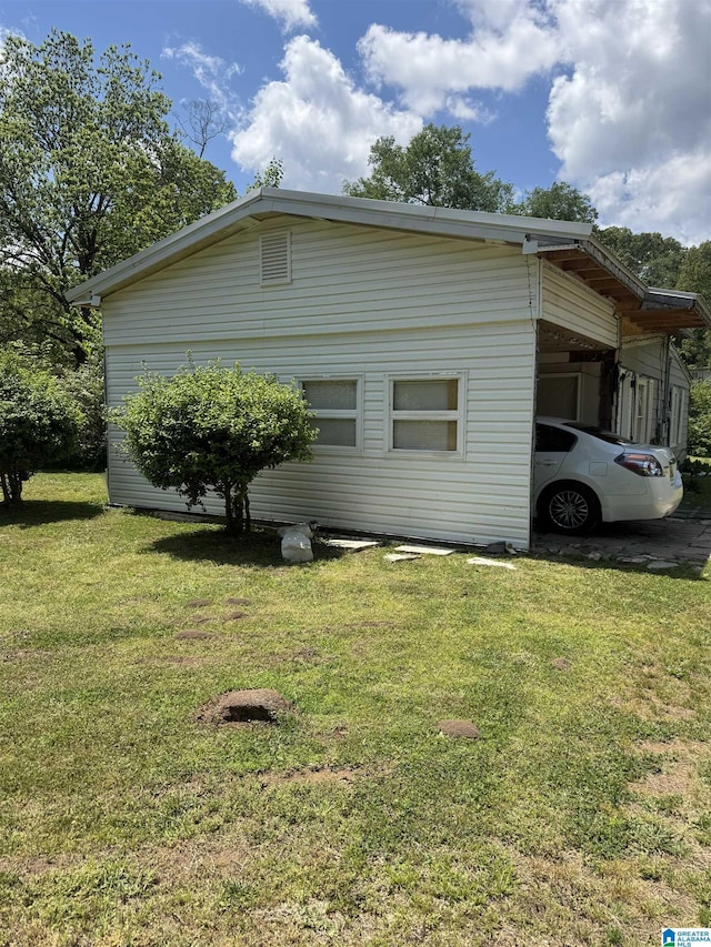 view of side of property with an attached carport and a yard