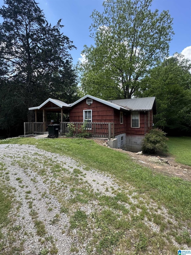 view of front of property with metal roof and a front lawn