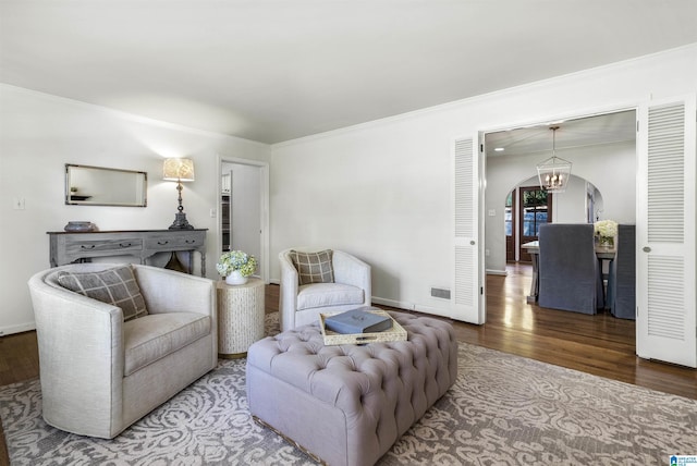 1856 Southwood Rd, Vestavia Hills, AL 35216 - living room featuring arched walkways, wood finished floors, baseboards, a notable chandelier, and ornamental molding
