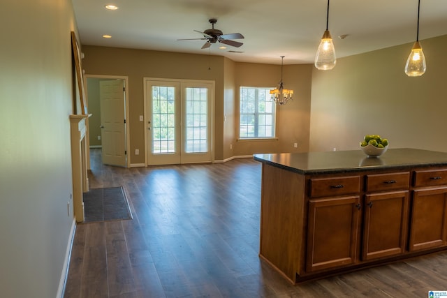 kitchen featuring dark countertops, baseboards, ceiling fan with notable chandelier, and dark wood finished floors