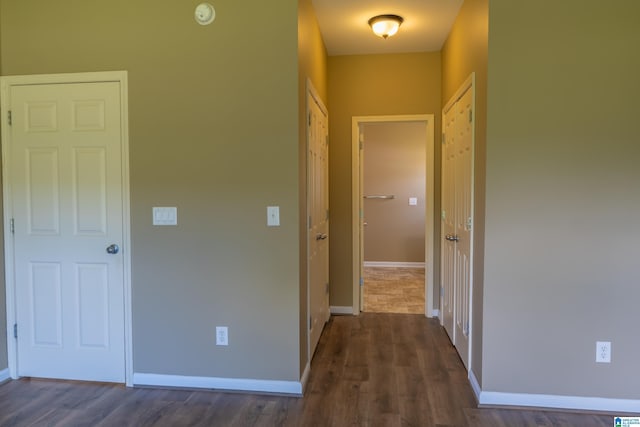 corridor with baseboards and dark wood finished floors