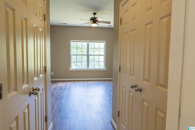 spare room featuring baseboards, ceiling fan, wood finished floors, and visible vents