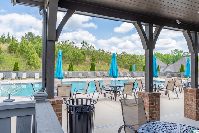 view of patio / terrace featuring fence and a community pool