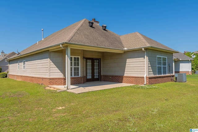 back of house featuring french doors, a lawn, cooling unit, and a patio area