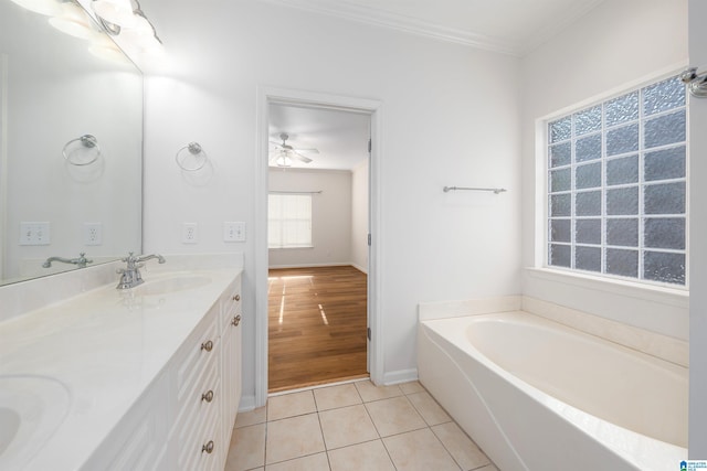 bathroom featuring a garden tub, double vanity, tile patterned flooring, ornamental molding, and a sink