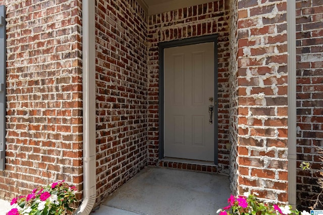 property entrance featuring brick siding