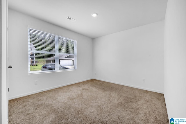 carpeted empty room with visible vents and baseboards