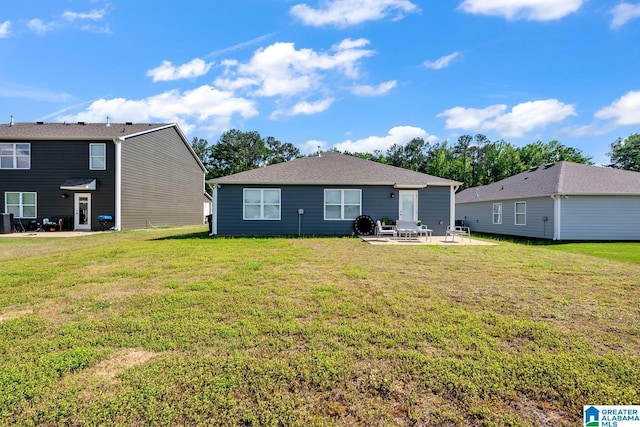 rear view of property with a yard and a patio area