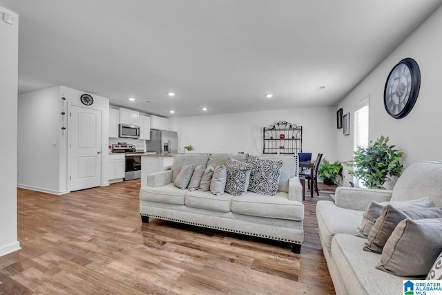 living area with recessed lighting, light wood-style floors, and baseboards