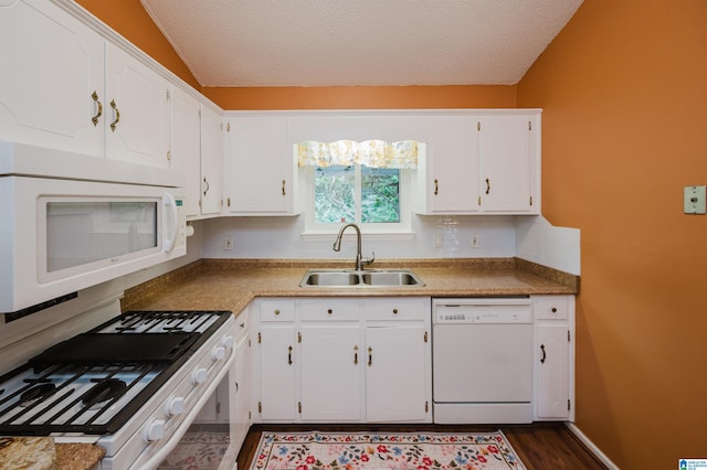 kitchen with a sink, dark wood finished floors, white cabinets, and white appliances