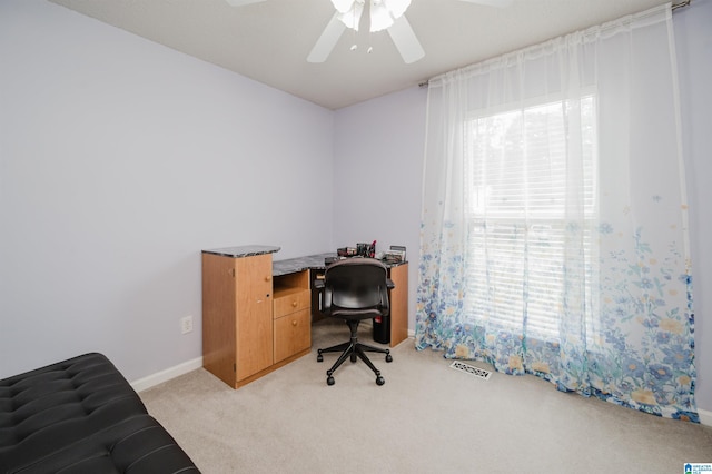office area with baseboards, ceiling fan, visible vents, and light colored carpet