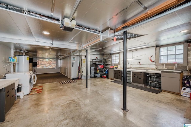 basement with a sink, washing machine and dryer, and gas water heater